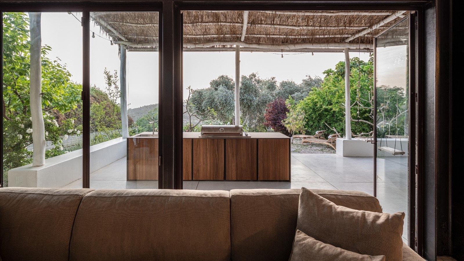 STRATO island beside outdoor sofa under pergola